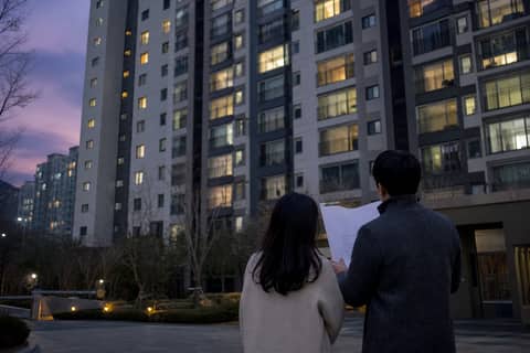 저녁의 아파트 단지를 함께 바라보는 부부